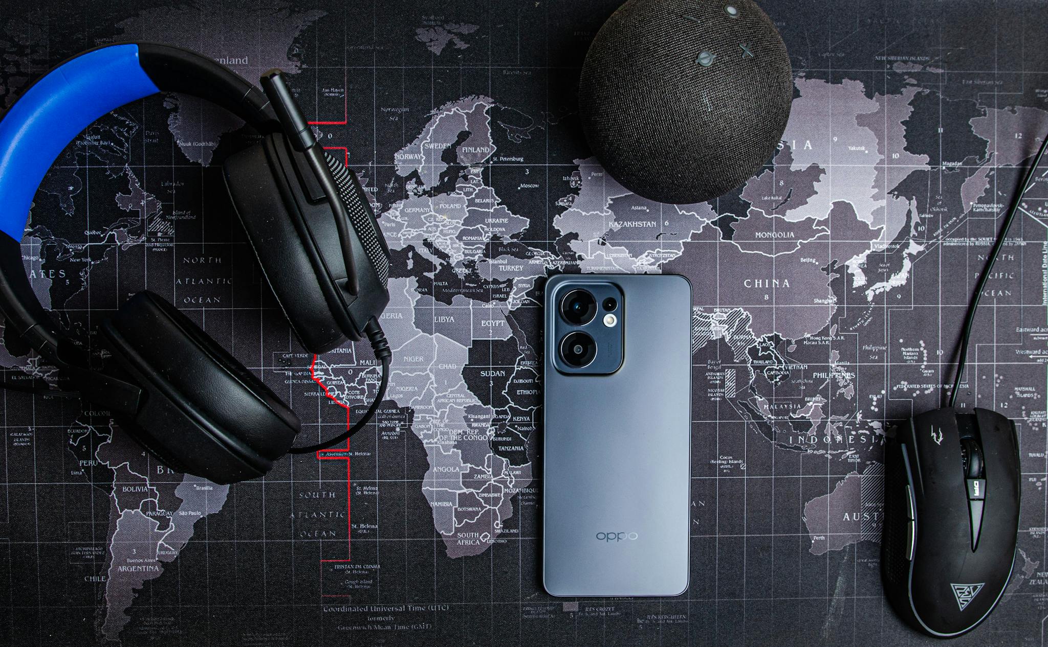 Smartphone, headset, and accessories on a world map background, perfect for tech and travel themes.